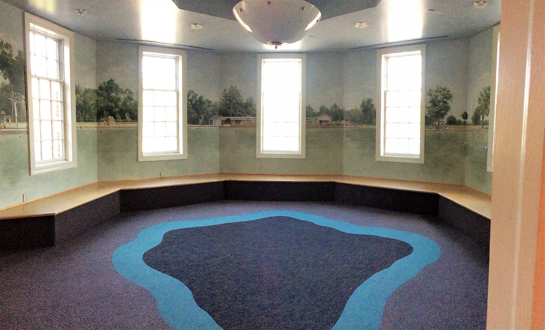 The story tower, located in the Children's Room, is circular, has bench seating around the perimeter, and is decorated with a mural of Graydon Pool.